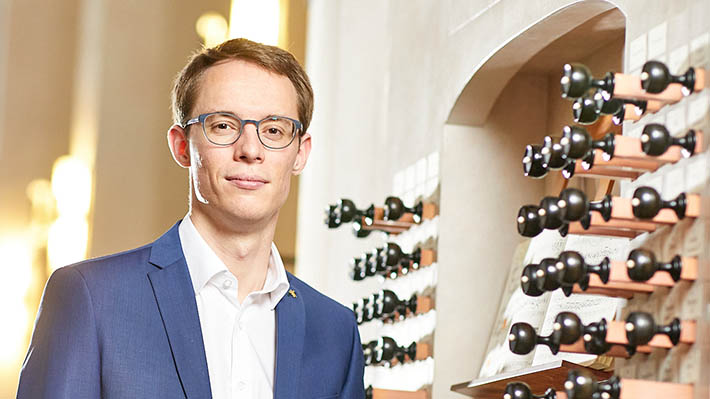 Organist Johannes Lang vor einer Orgel